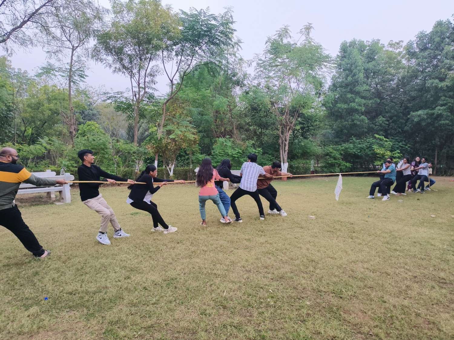 A man swinging a bat during a casual game of cricket on a grassy lawn