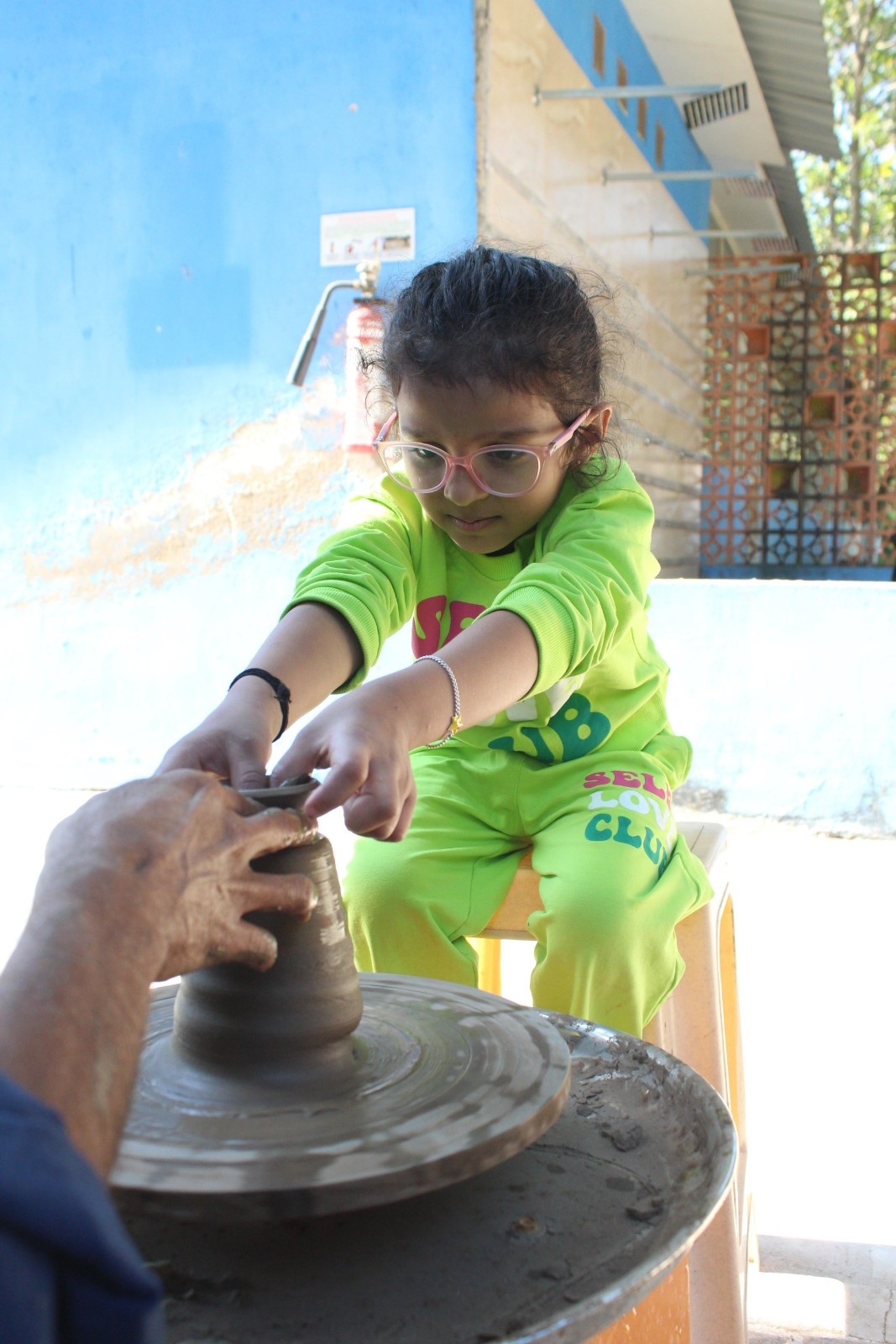 Young girl shaping clay on a pottery wheel