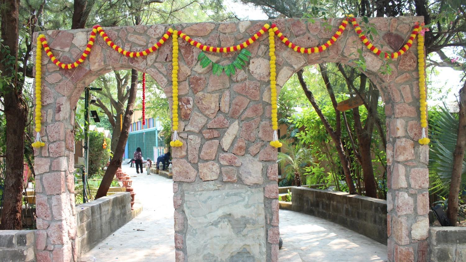 Charming whitewashed cottage with a thatched roof surrounded by flowering plants and wooden deck