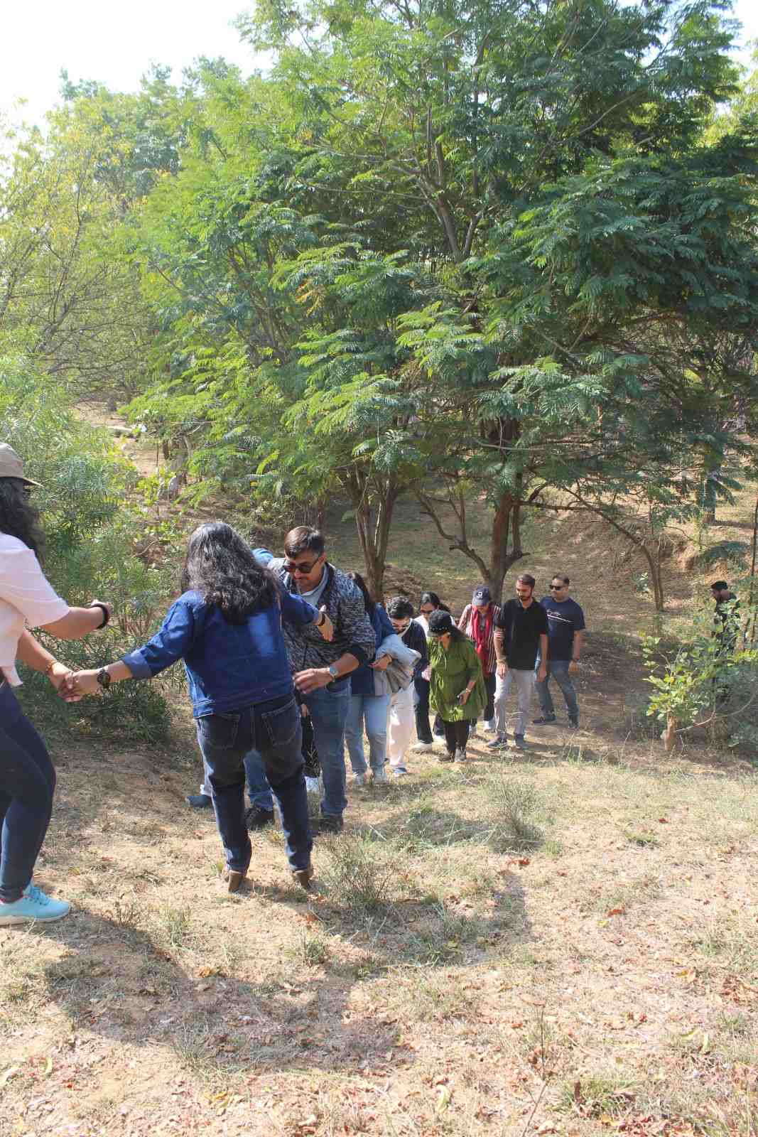 Team helping each other climb hill