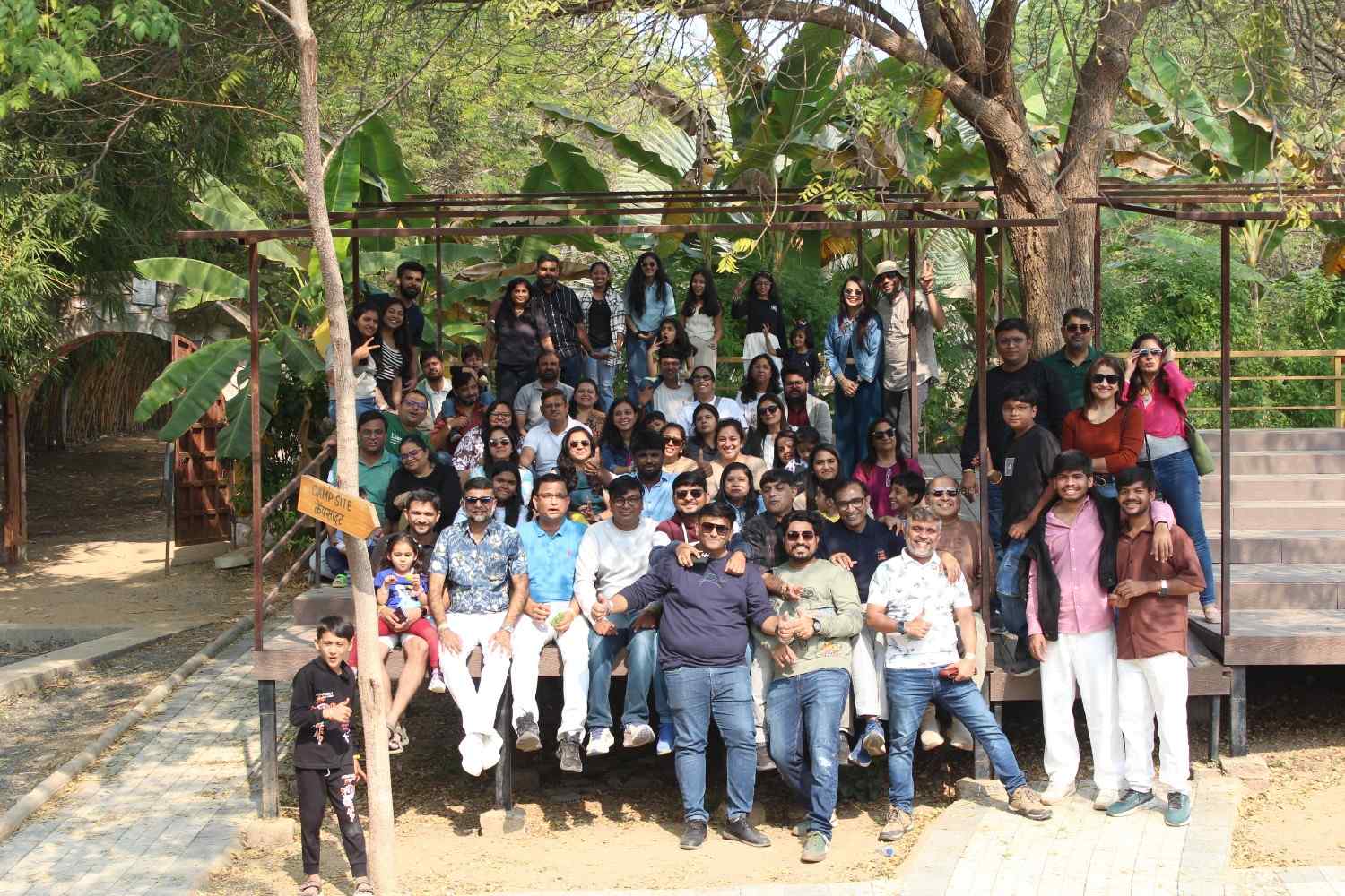 Large corporate team posing for a group photo on a wooden deck