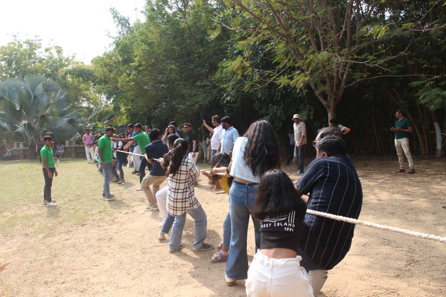 Employees participating in a tug of war competition outdoors