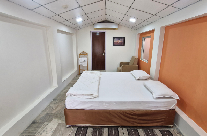 Charming whitewashed cottage with a thatched roof surrounded by flowering plants and wooden deck