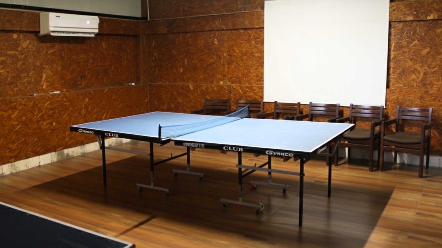 Charming whitewashed cottage with a thatched roof surrounded by flowering plants and wooden deck