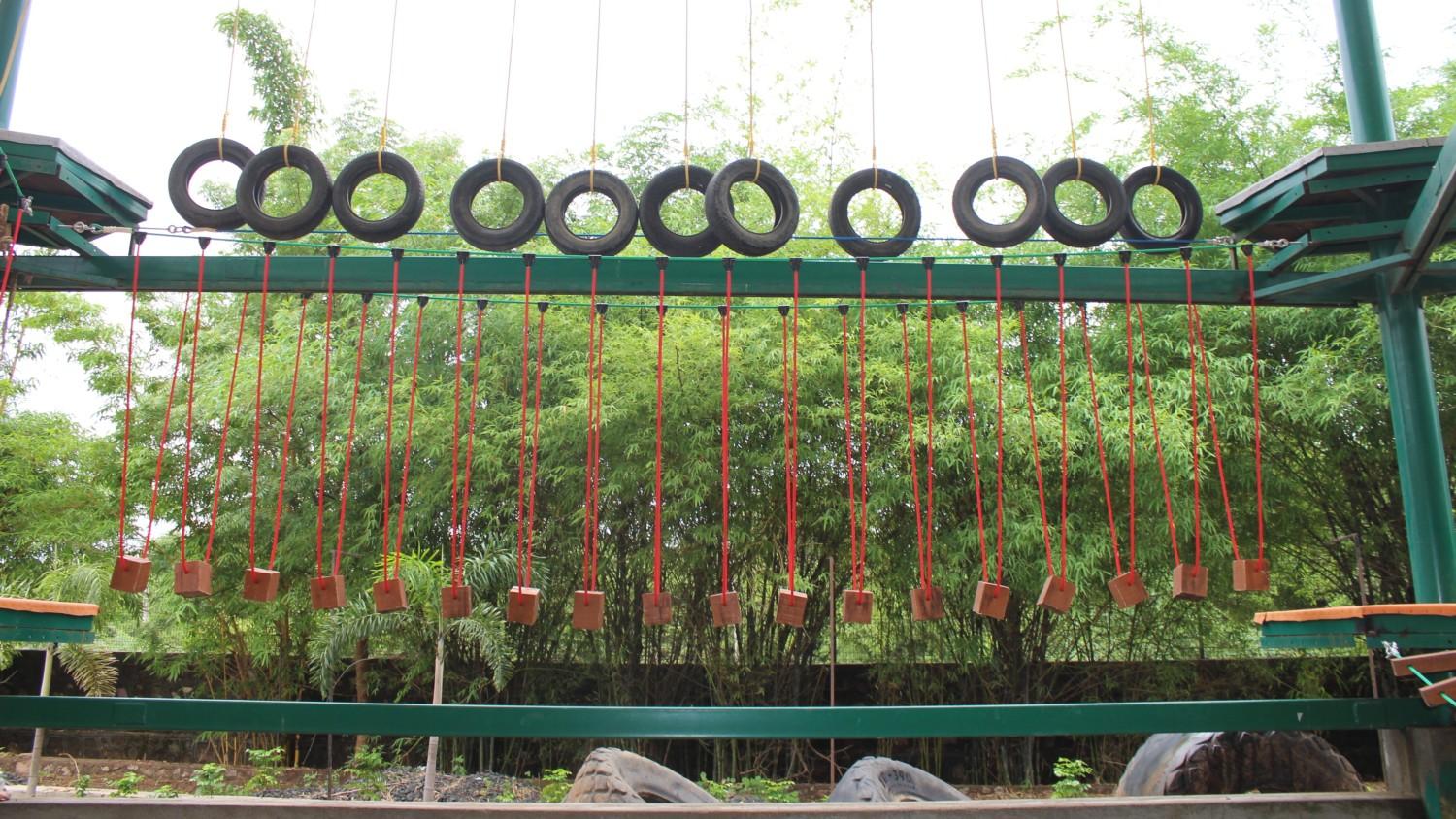 Private garden with wooden chairs and hammock surrounded by colorful flowers and shady trees